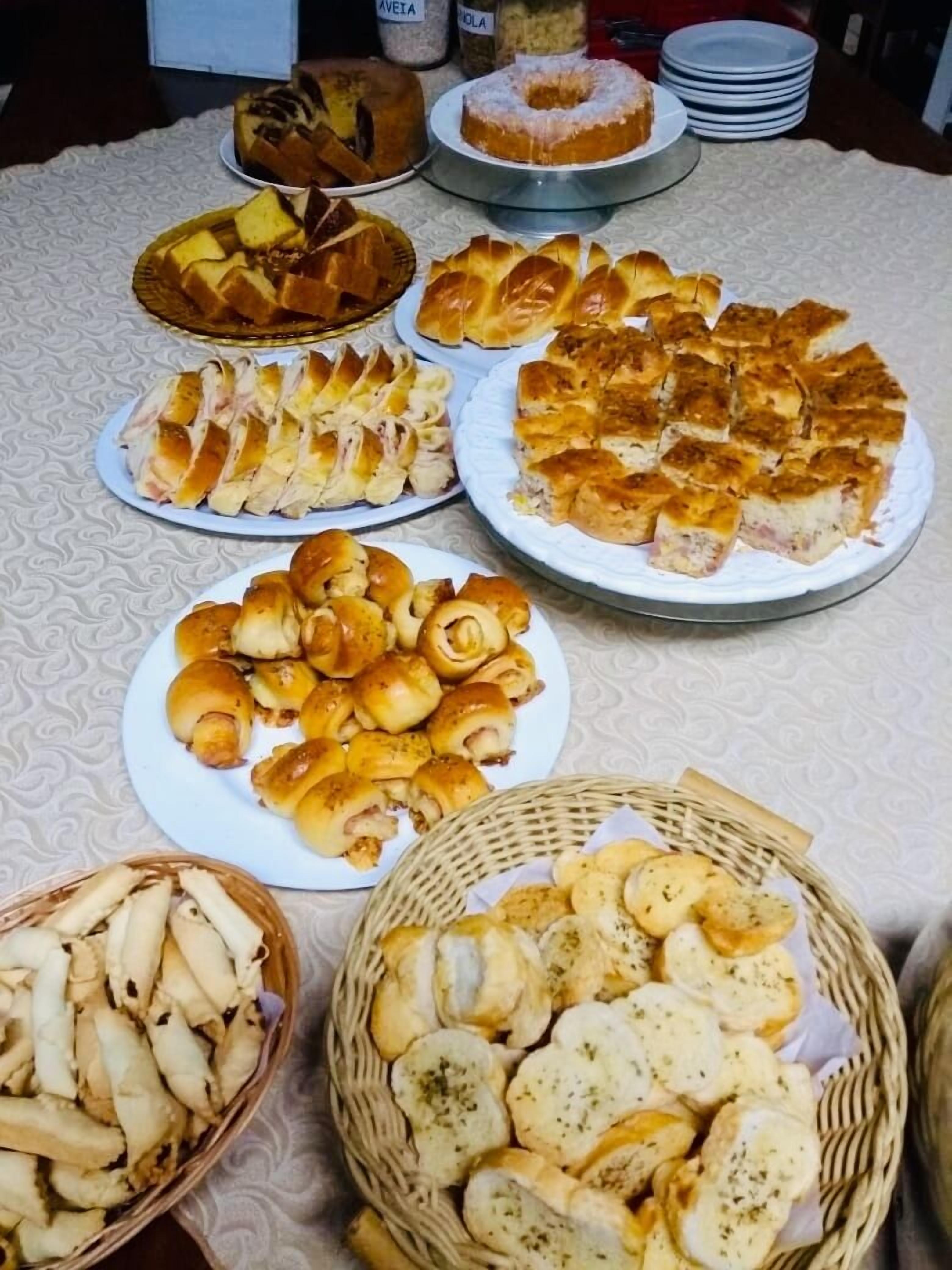 Uma mesa com diversos produtos de panificação, incluindo pão, pães e doces.