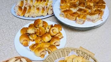 Uma mesa com diversos produtos de panificação, incluindo pão, pães e doces.