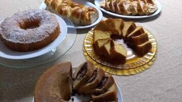 A table with various baked goods including cakes and pastries.
