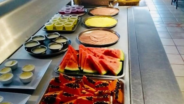 Un buffet proposant une variété de plats, notamment de la pastèque, de la papaye et d’autres fruits.