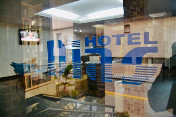 A hotel interior with a reception area, a staircase, and a view of the lobby. - Hotel Dias em Pouso Alegre-MG (Pouso Alegre)
