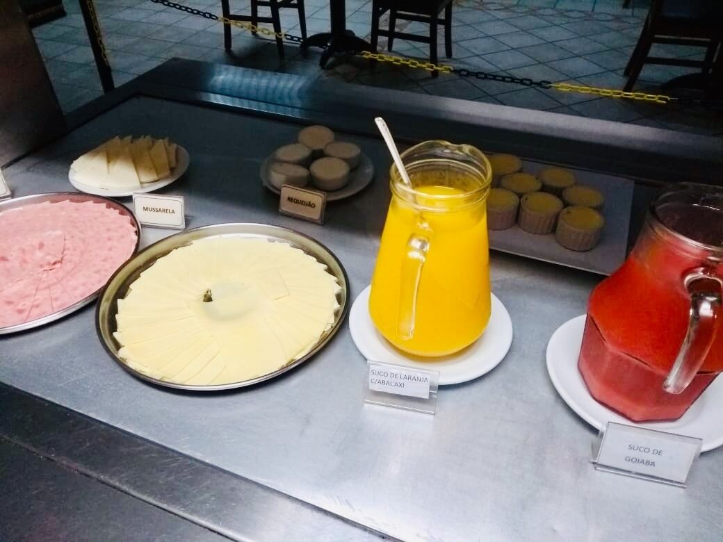 Um buffet de café da manhã com diversas opções de comida e bebidas.