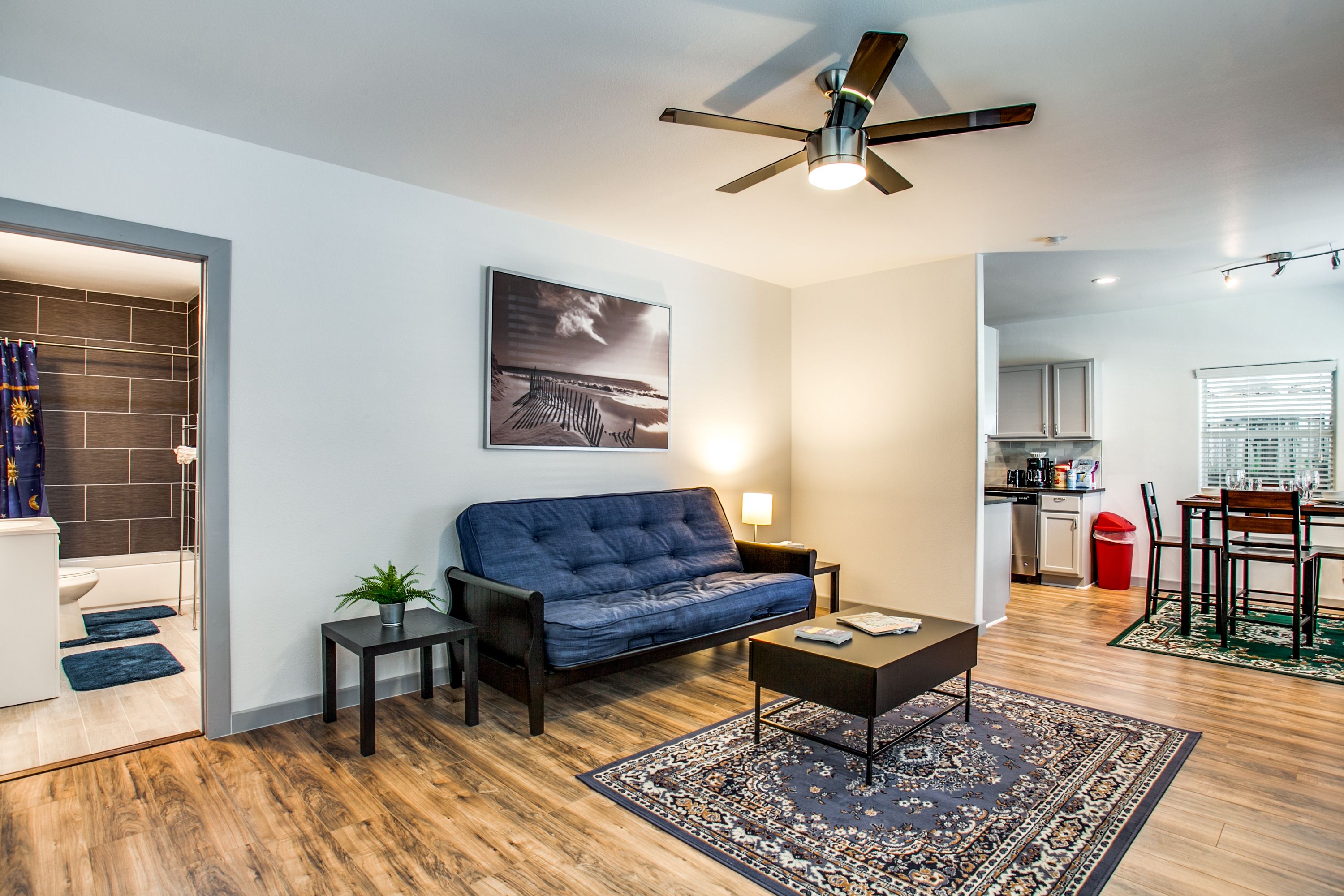 A modern living room with a sofa, coffee table, and a ceiling fan.