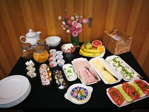 A buffet table with various food items including fruits, cheeses, and meats. - Portofino (Wloclawek)