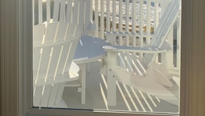 A view of the ocean from a deck with white chairs and a railing. -  Cape May Beach- Luxury Delaware Bay Beauty- Heated Pool-Linens (Cape May Beach)