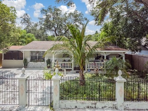 A house with a covered porch, a fountain, and a gated entrance. - #1 LOCATION - Walk to Amusement Parks from PERFECT HOME, Great for Families 🏠 (Tampa)