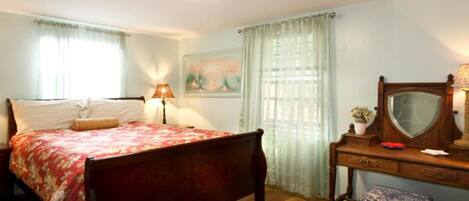 Un dormitorio con cama, cómoda, espejo y lámpara.