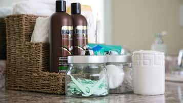 A bathroom counter with toiletries, a wicker basket, and a glass jar with green items.