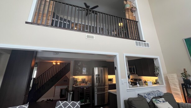 Un appartement moderne doté d’une cuisine, d’un coin repas et d’un balcon avec des balustrades.