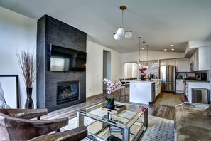A modern living room with a fireplace, a glass coffee table, and a sofa. - Monthly  1 Story, 3 Bdr Gorgeous Home Summerlin Pet Friendly (Las Vegas)