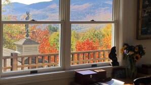 A room with a large window offering a view of autumn foliage and mountains. - EPIC Mountain View Home : Minutes to Skiing!! (Jackson)