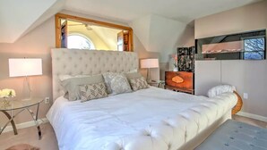 A bedroom with a large bed, two bedside tables, a mirror above the bed, a dresser, and a television on the wall. - EPIC Mountain View Home : Minutes to Skiing!! (Jackson)