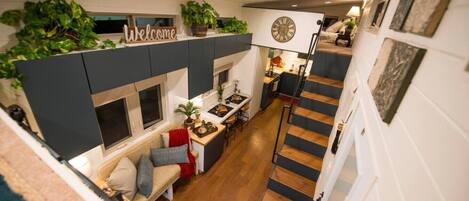 A compact living space with a kitchen, dining area, and a staircase.
