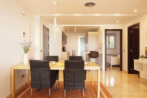 A modern dining area with a long table, four chairs, and a hanging light fixture. - Ground floor apartment with amazing views-Fl8-1 (Ojen)