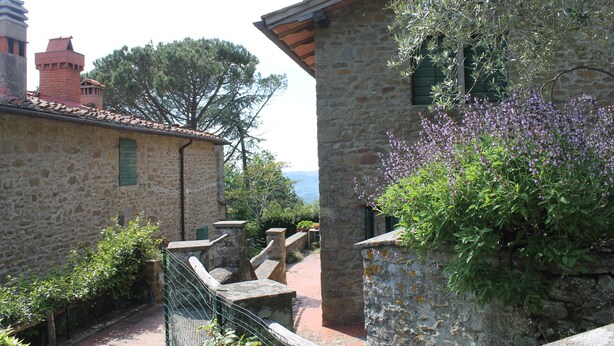 A stone building with a rustic staircase and a view of the sea. - Podere I Rovai-apt IL RIFUGIO-amazing view Tuscany (Reggello ( Firenze ))