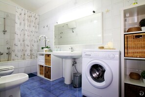 Een bad/douchecombinatie, een haardroger, een bidet, handdoeken