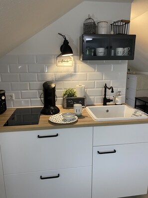 Een koelkast, een oven, een kookplaat, een koffiezetapparaat/waterkoker