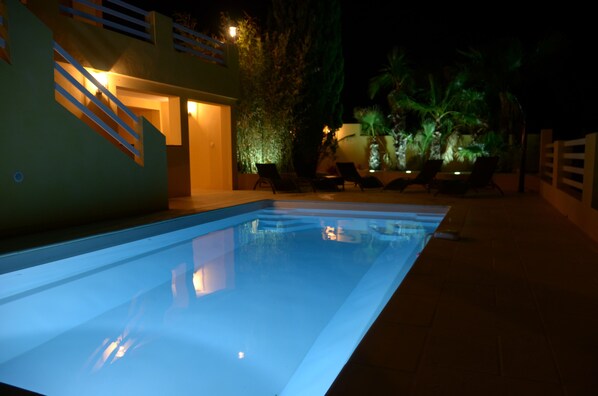 A swimming pool with a clear water surface, surrounded by lounge chairs and a staircase leading to an upper level. - Magnificent Villa with dominant view and heated swimming pool   (Langlade)