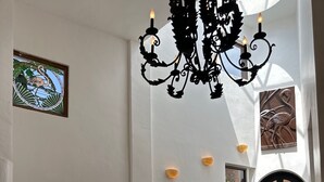 En rummelig lobby med en imponerende trappe, en lysekrone og en stor vase.