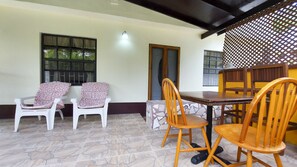 A dining area with a table and chairs, a patterned wall, and a window with a view.