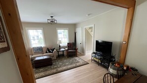 Una sala de estar amplia con sofá, sillón y televisión.