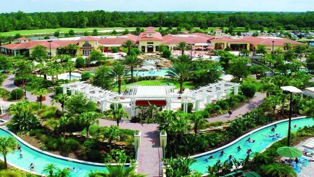 Ein Resort mit einem zentralen Pool, mehreren Gästegebäuden und üppiger Bepflanzung.