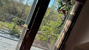 A room with a sliding glass door leading to an outdoor deck. - Mountain Top Eureka Springs Cabin with Full Glass Front Best Views in Eureka (Eureka Springs)