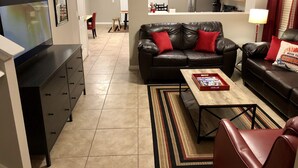 A modern living room with a leather sofa, a TV, and a coffee table.