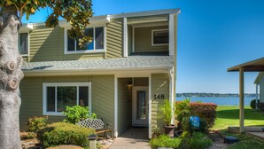 A two-story house with a number 148 sign, a covered porch, and a view of a body of water. - WATERFRONT CONDO  WITH AMAZING VIEW OF SUNRISE, SUNSET AND EXPANSIVE OPEN WATERS (Montgomery)