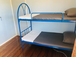 Ein Etagenbett mit zwei Schlafstellen, jeweils ausgestattet mit einer Matratze und Kissen.