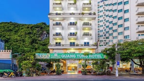 A hotel with a prominent sign, multiple balconies, and a lush green environment.