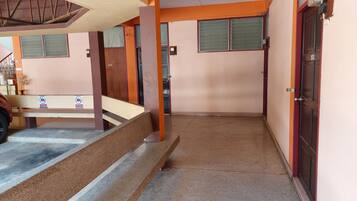 A narrow corridor with a bench, a door labeled "101", and a staircase leading to an upper level.
