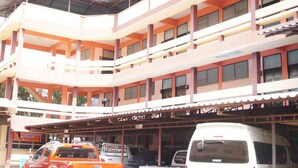 A multi-story building with a covered parking area. - Sataya Apartment (Maha Sarakham)