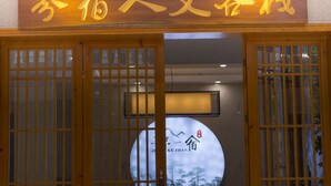 A traditional Chinese building entrance with wooden doors and a sign in Chinese characters.
