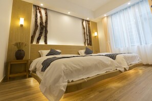 A modern bedroom with a wooden headboard, two beds, bedside tables, and a large window with sheer curtains. - Jiesu Renwen Guest House (Zhangjiajie)