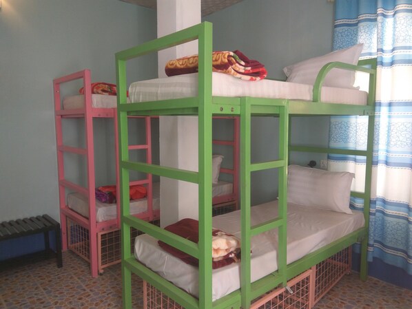 Bunk beds with pillows and blankets, a tiled floor, and a window with curtains. - Hostel Roma Inn (Kalaw)