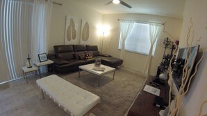 A living room with a sofa, coffee table, bench, and decorative items. - Aco63675 - Bella Vida Resort - 4 Bed 3 Baths Townhouse (Kissimmee)