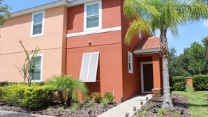 A two-story building with a red exterior, white window frames, and a small front porch. - Aco63675 - Bella Vida Resort - 4 Bed 3 Baths Townhouse (Kissimmee)