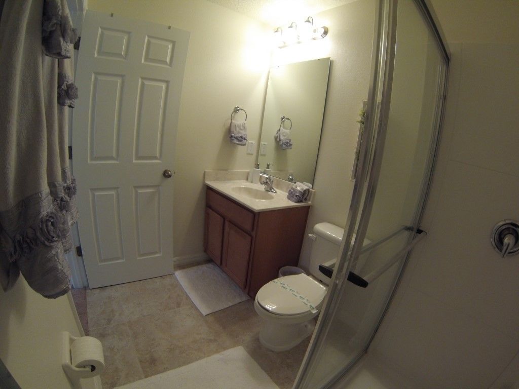 Un baño con inodoro, lavamanos y espejo.