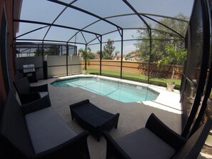 Une piscine extérieure couverte, dotée de chaises longues et d’un barbecue.