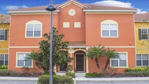 A two-story building with a red facade, a central entrance with a door, and two windows on each floor. - Ip60387 - Paradise Palms - 5 Bed 4 Baths Townhome (Kissimmee)