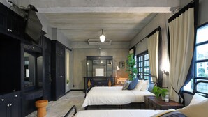 Une chambre à coucher avec un lit, des tables de chevet, une commode, un miroir et une fenêtre avec des rideaux.
