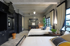 Une chambre à coucher avec un lit, des tables de chevet, une commode, un miroir et une fenêtre avec des rideaux.