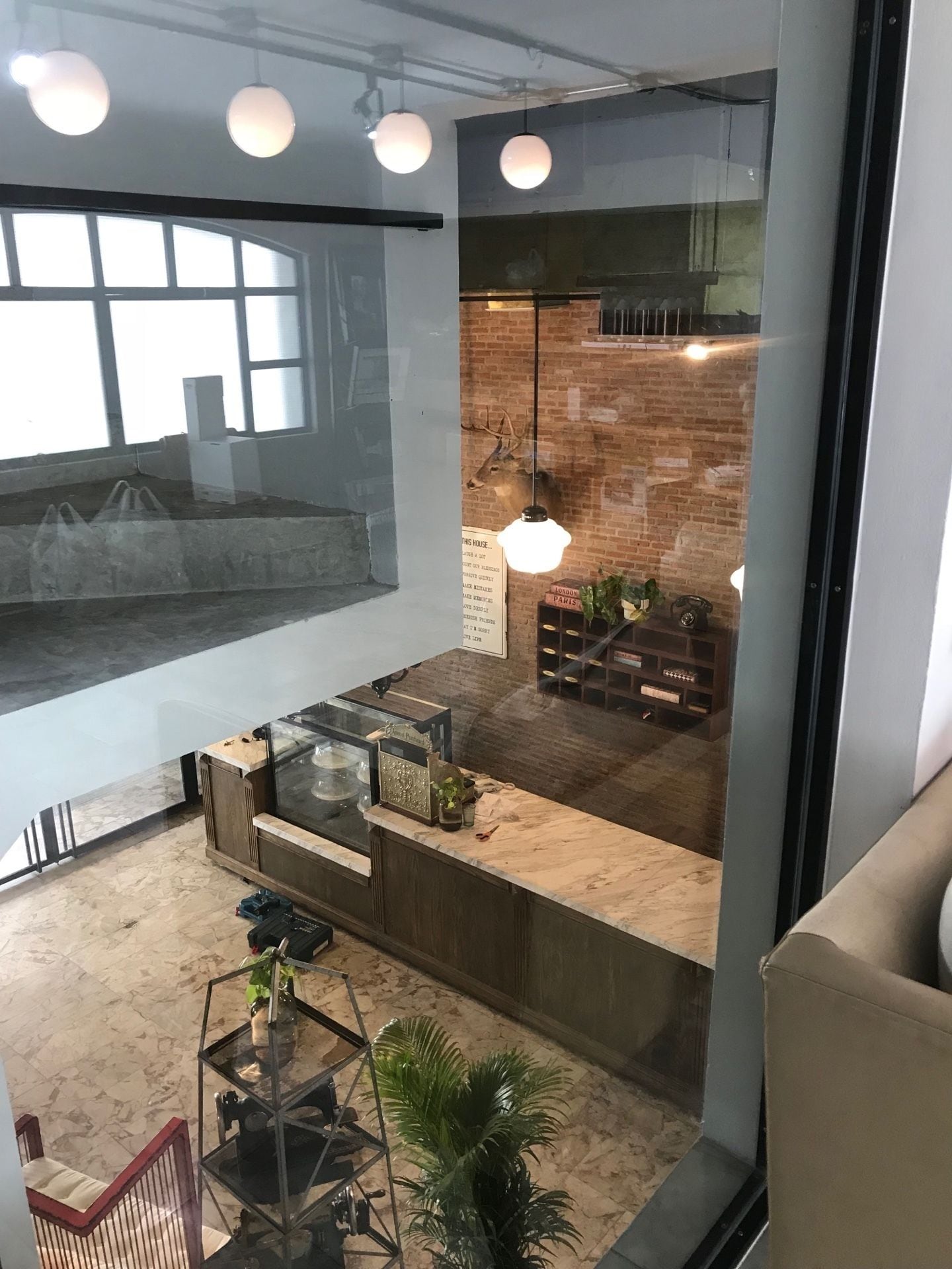Un intérieur moderne avec un mur de verre, un mur de briques et un comptoir en bois.