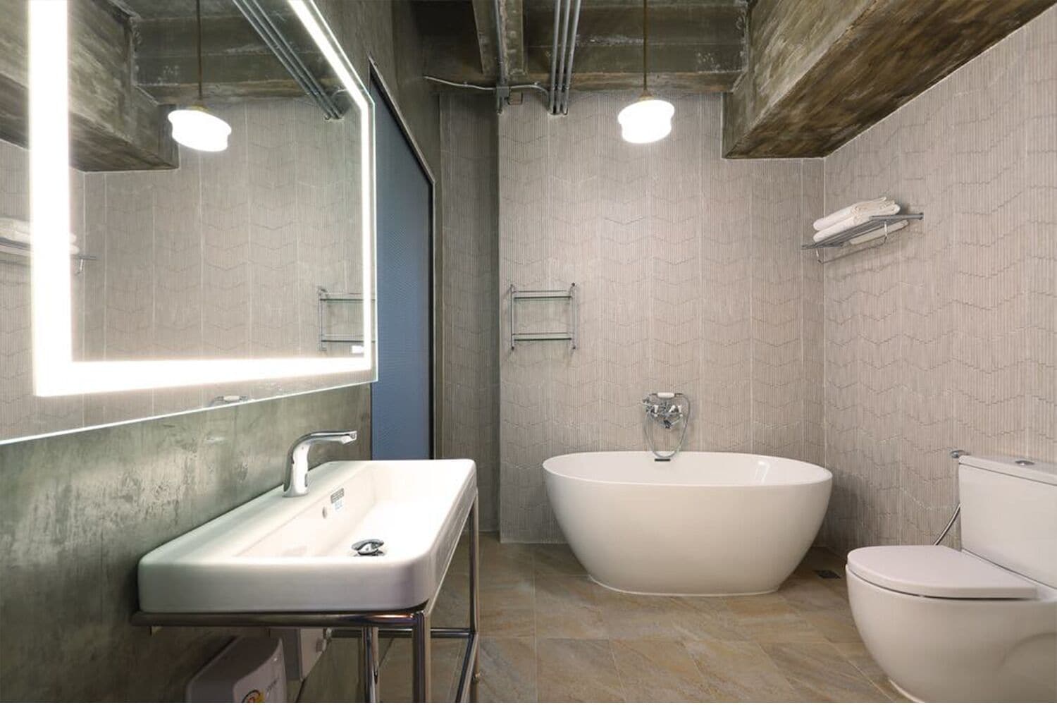 A modern bathroom with a freestanding bathtub, a sink, and a toilet.