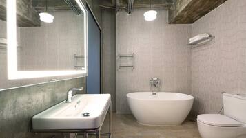 A modern bathroom with a freestanding bathtub, a sink, and a toilet.