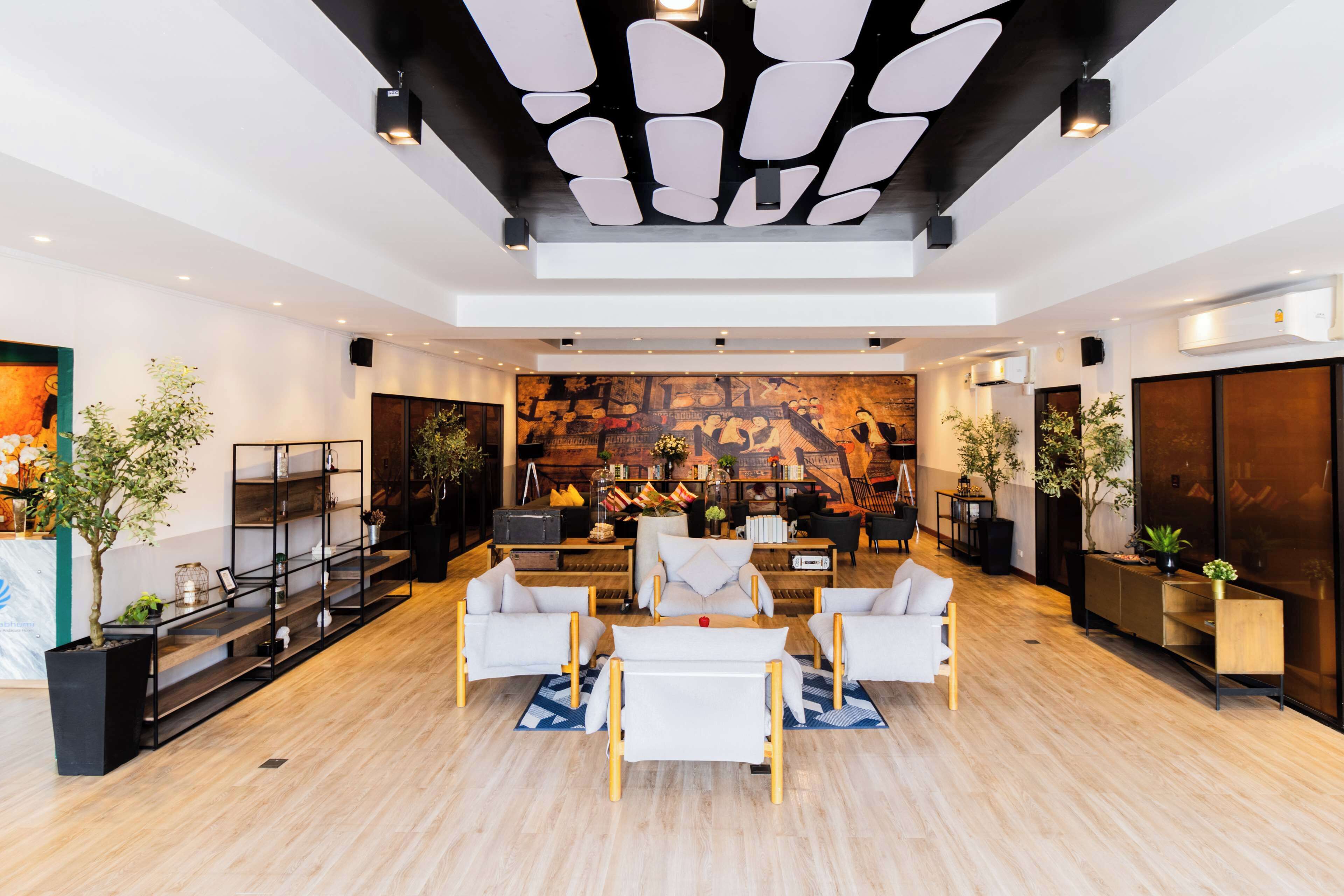Un salón amplio y moderno con techo alto, muebles contemporáneos y un gran mural en la pared de fondo.