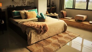 A well-lit bedroom with a large bed, a bedside table, a chair, and a window with a view. - 5 Min Ninman Road & Best Mountain View (Chiang Mai)
