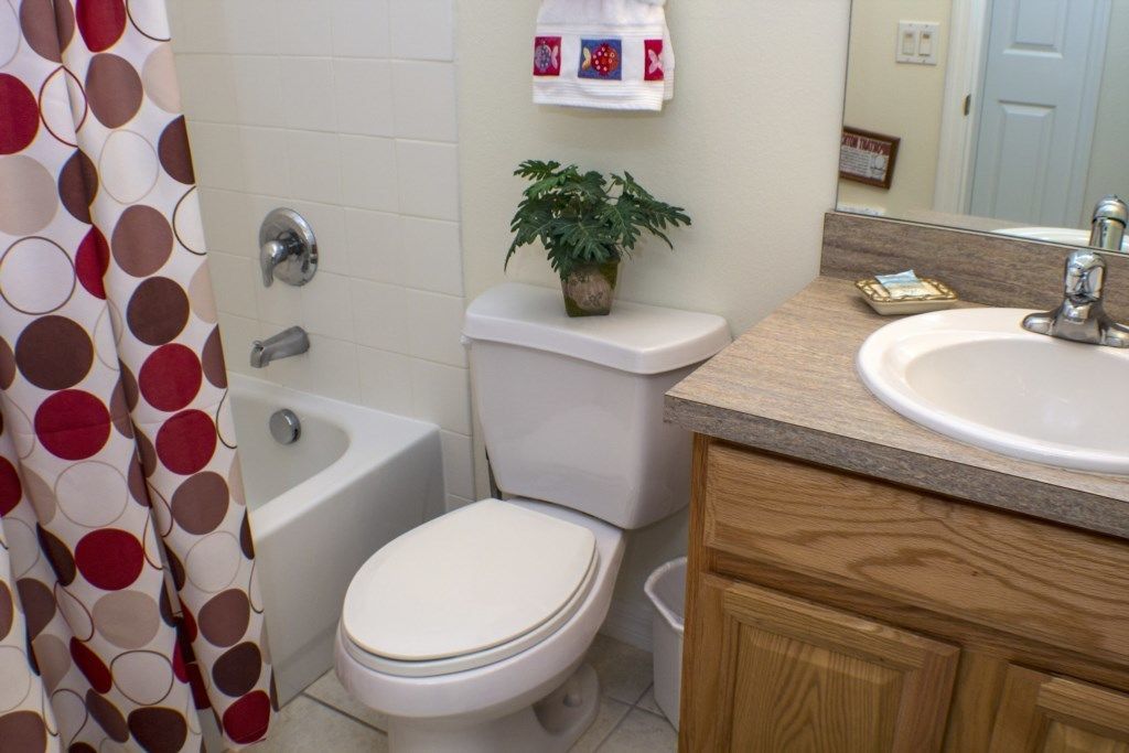 Une salle de bain comprenant des toilettes, un bidet, une baignoire et un lavabo avec un miroir au-dessus.