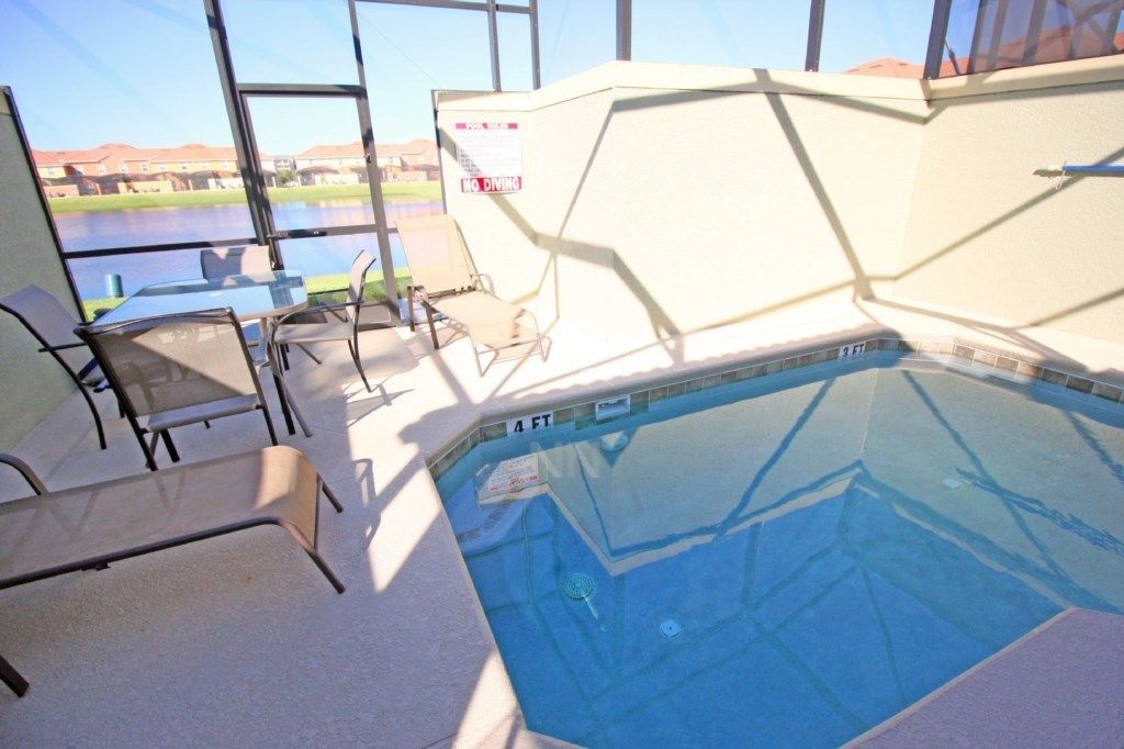 An indoor swimming pool with clear glass walls, a view of a body of water outside, and a 'No Diving' sign.